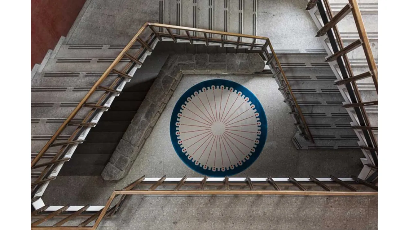 Round carpet CoDeco with a blue frame by Carpet Edition.